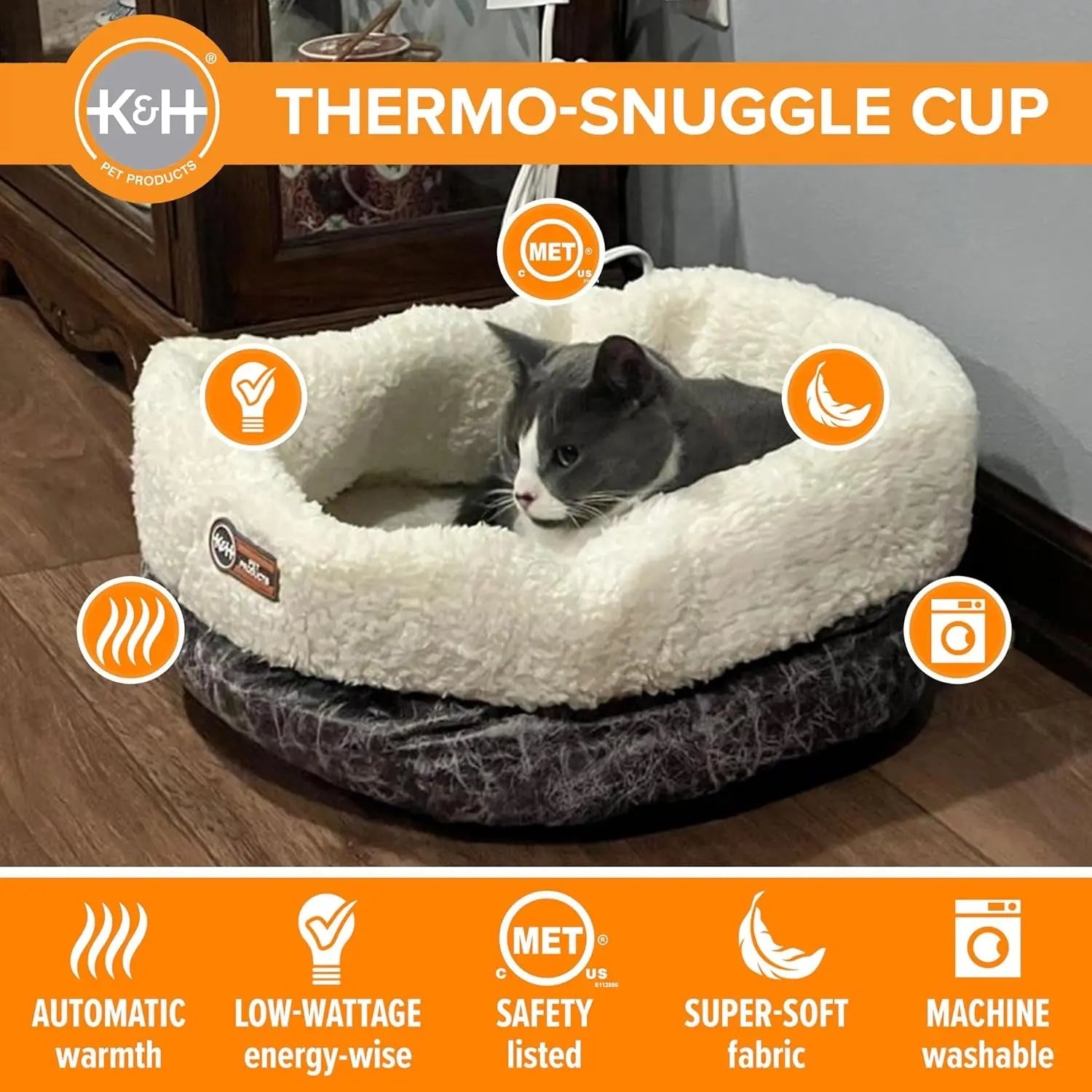 Gray and white cat in a fluffy, cream-colored heated pet bed with orange icons and text.