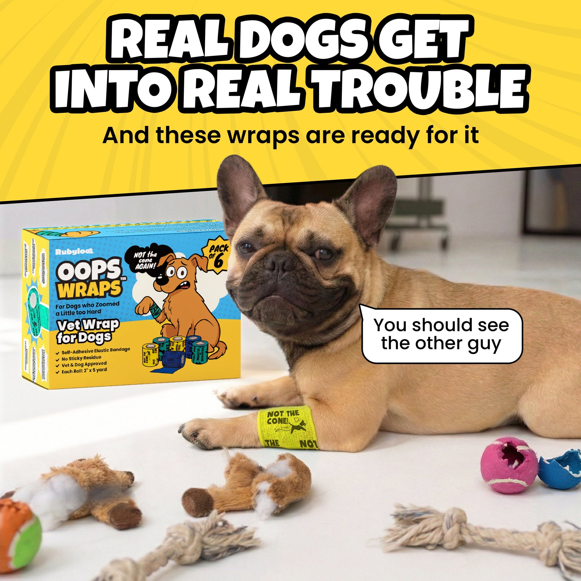A French Bulldog with a yellow bandage lies among toys; a box of "Oops Wraps" is behind.