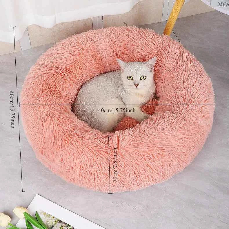 Gray cat in a fluffy pink round bed on a light gray floor, with measurement markings.