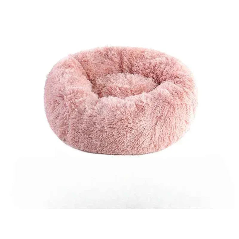 Pink fluffy round pet bed with a plush, cozy texture on a white background.