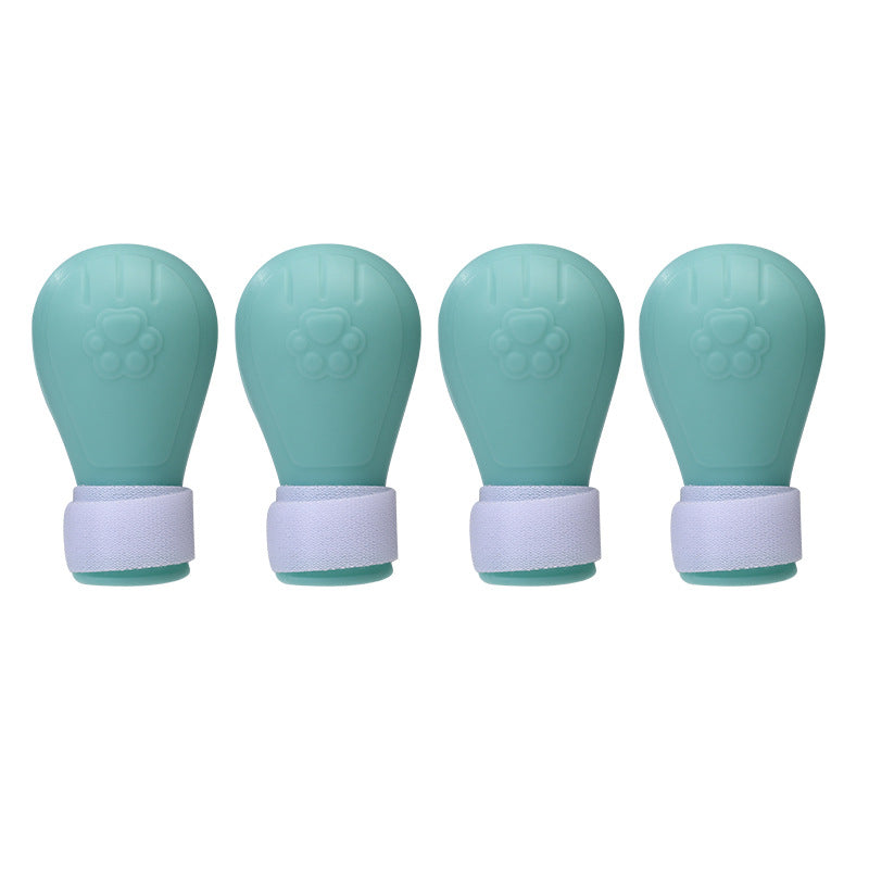 Four teal silicone travel bottles with white caps, arranged in a row.