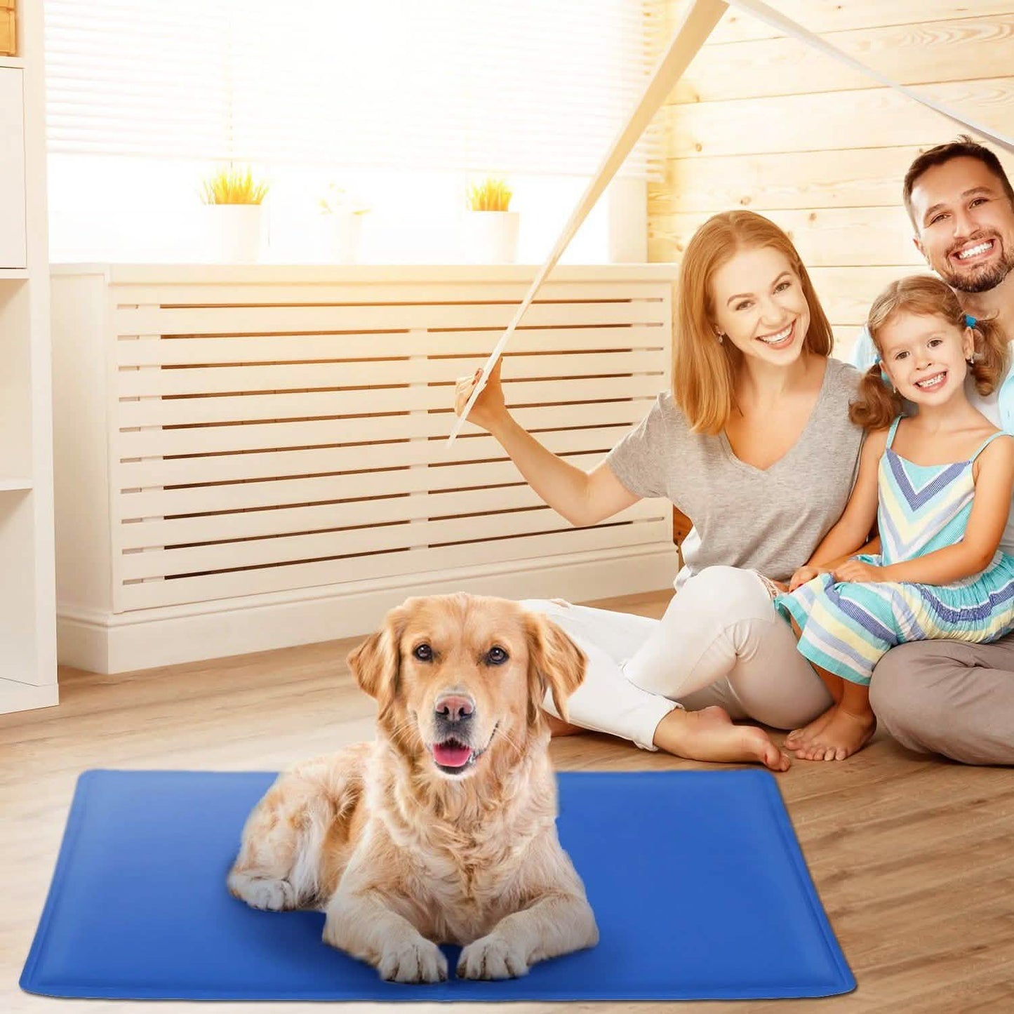 Family with dog on blue mat in bright room, woman holding a white sheet overhead.